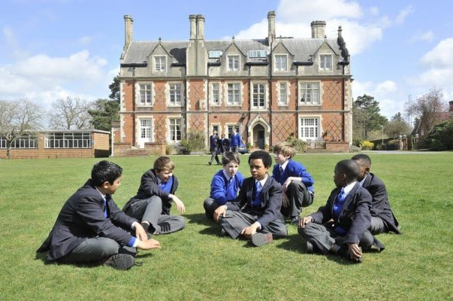 British children and international exchange students playing together at school in England