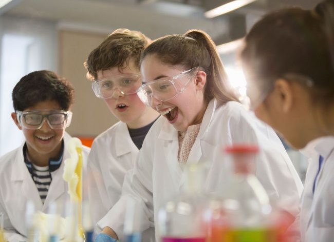 UK high school students and international exchange students enjoying science class in a British state boarding school