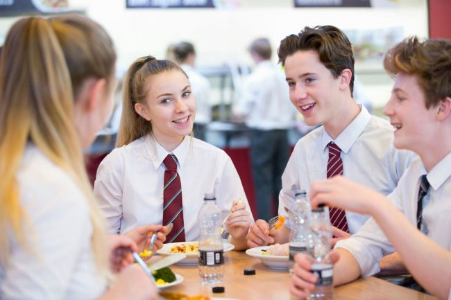 UK students and international exchange students having lunch in a British state boarding school